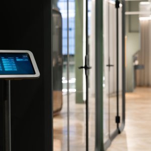 كبينة Framery One Compact داكنة بجوار محطات العمل
